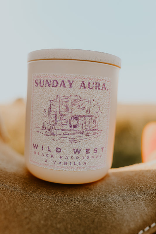 Candle with 'Sunday Aura' label on a textured surface