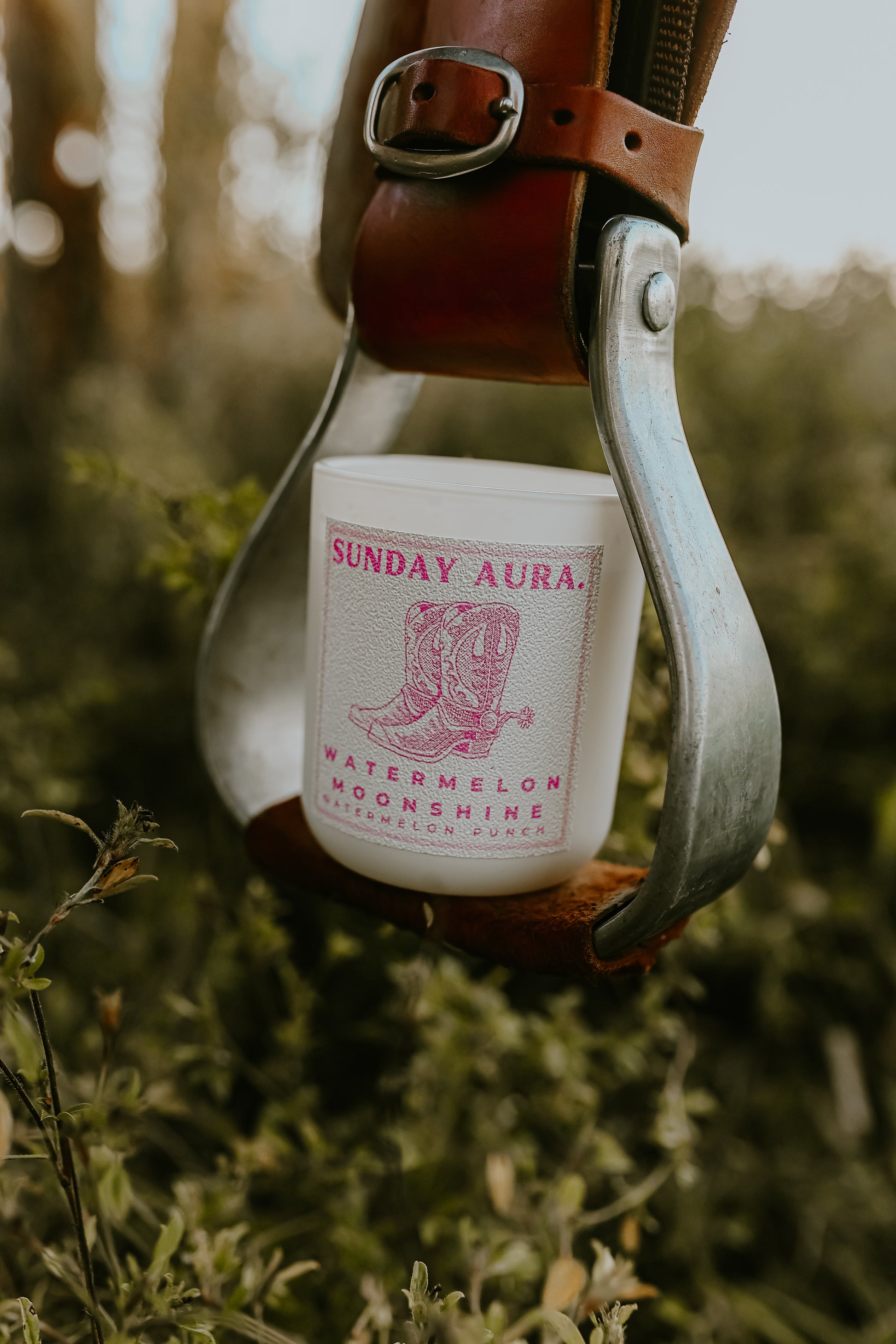 Bottle of Sunday Aura watermelon moonshine in a rustic setting with a blurred natural background